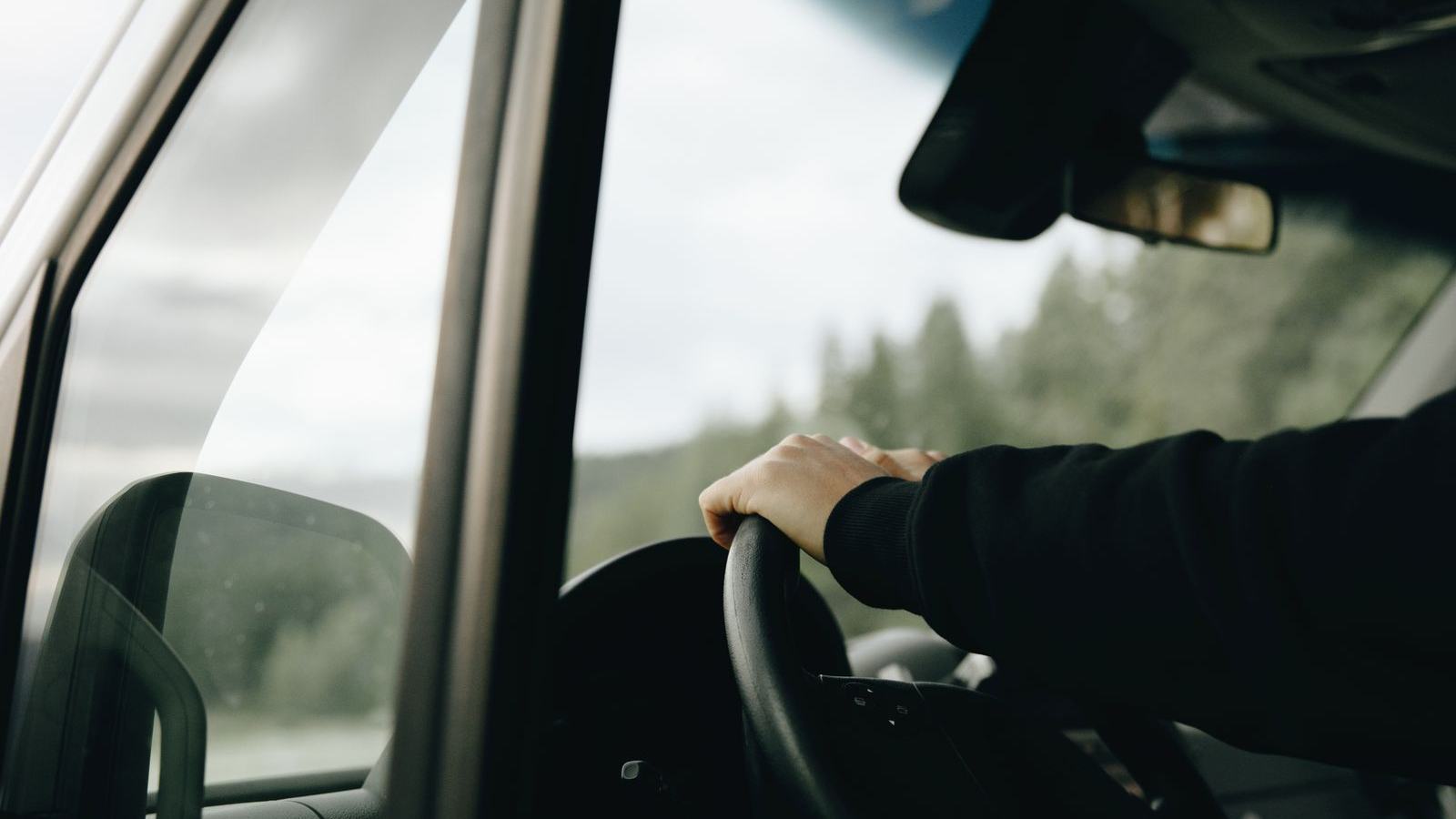 運転席でハンドルを握る手