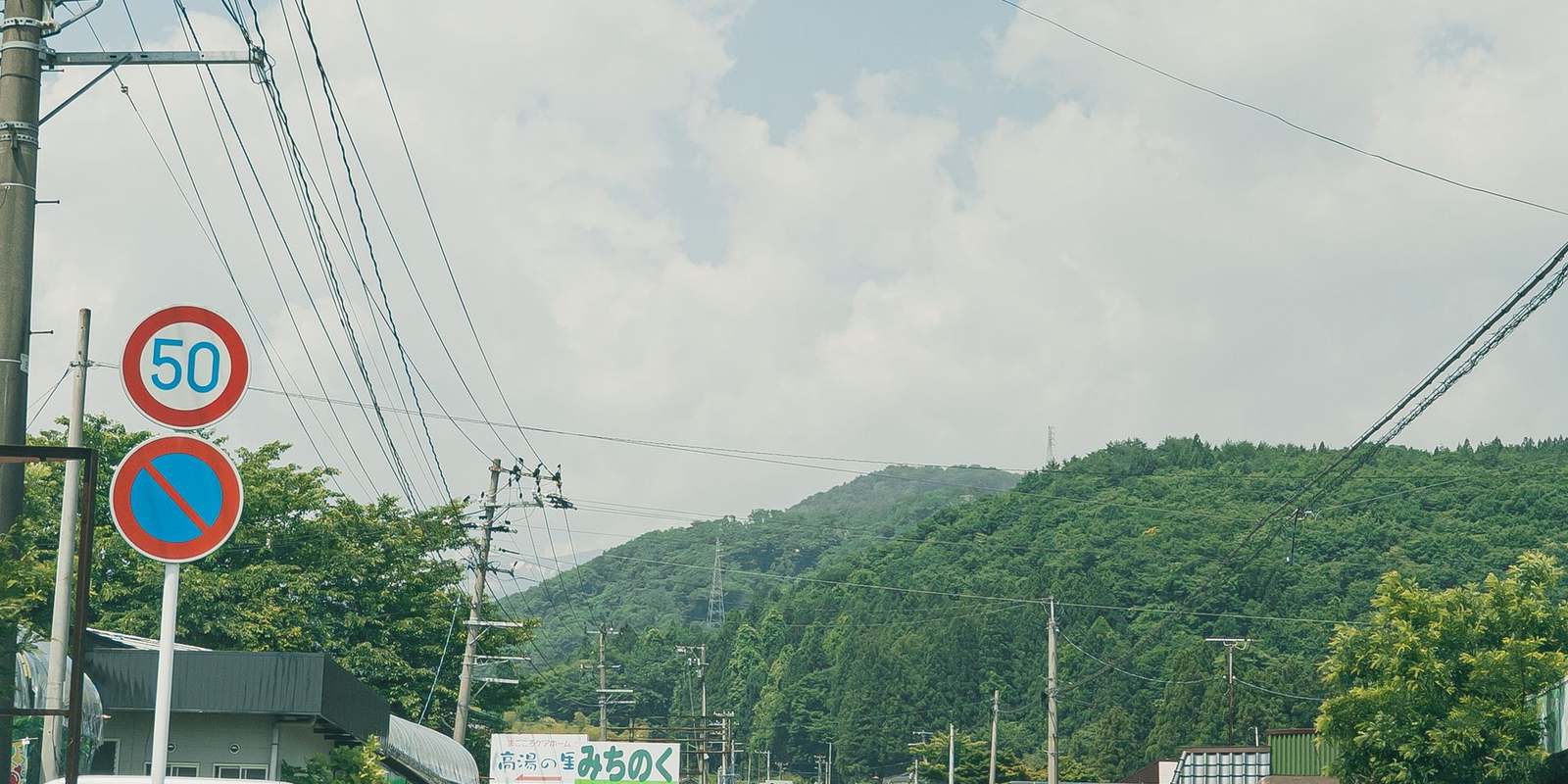 山あいの集落を通る細い道路と民家